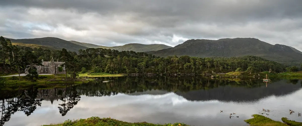 The loch and lodge beneath the hills